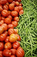 Tomatoes & green beans on display in market.