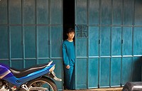 Young Indonesian girl in the doorway of her home in the city of Tanjungpinang on Bintan island, Indonesia