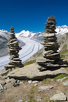 Piled stones to mark the road in the mountains  Valley glacier with its longitudinal moraines of the Glacier Alesht  At the bottom the summits of the ...