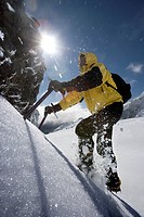 Mountaineer climbing snow covered mountain