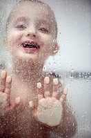 Two year old boy playing during his bath