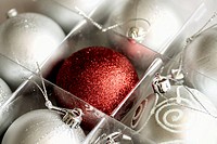White Christmas balls and a red Christmas ball A box of eight satin white Christmas balls with a crimson ball in the center The red ball has a glitter...