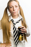 Teenage schoolgirl wearing school uniform smoking cigarette and drinking a can of cider