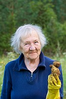 Old woman smiling and showing a strangely shaped potato