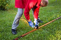 A man using a disk cutter to cut a rusted pipe