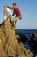 Extreme ironing, ironing a shirt on top of a rock pinnacle Houghton Bay Wellington New Zealand