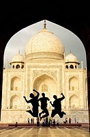 Tourist teens jumping in front of the Taj Mahal Agra, India