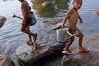 Laos, Bolaven plateau, Se Set river, two young boys carrying water from the river for irrigation.