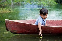 Guatemala, Rio Dulce, young boy in canoe