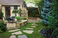 Flagstone path across lawn leads to flagstone patio, garden shed, fireplace, covered spa