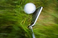 GOLF Blurred motion of club and golf ball in heavy grass on course in Deerfield, Illinois