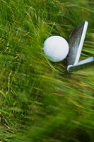 GOLF Blurred motion of club and golf ball in heavy grass on course in Deerfield, Illinois