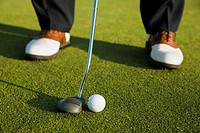 GOLF Adult middle aged male practice putting on green at public course in Deerfield, Illinois, address ball with putter