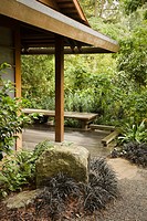 Gravel path bordered by Black Mondo Grass leads to Tateuchi Viewing Pavilion in Japanese garden
