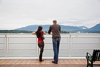 A young man and woman enjoying hte view of Burrard Inlet from Canada Place, Vancouver, British Columbia, Canada