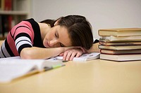 A young woman sleeping in a library