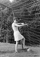 Sixties, black and white photo, people, young girl stands in a football goal and picks a football out of the net, jersey, sweater, aged 18 to 22 years...