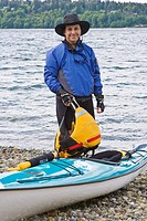 Woman kayaker on Colvos Passage shoreline of Vashon Island, Washington
