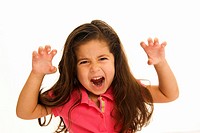 Four year old girl with long brown hair in pink top. She has both arms raised to the sides of her head, her hands at formed like claws she frowls at t...