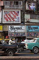A view of a street in Mumbai, near Bazar Chor, showing traffic and advertisments for ´henna tatoo´ and perfumers