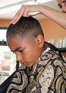 6 year old African American boy getting a hair cut  Making a face