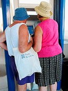 Couple using ATM, Crete, Greece
