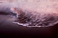 Waves reaching the shore of the beach at sunset