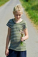 Young girl with flowers in her hand.