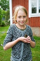 Young girl with baby duck on her hand.