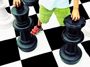 Boy playing on life-size chess board