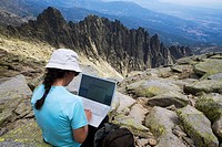 Woman on the summit of La Mira 2 341 m working with a portable computer  Mountains of the Sierra de Gredos National Park  At the bottom of the image t...