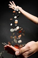 Coins dropping from one hand into another hand