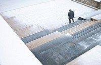 Old man walking under a snowfall on a park in Morella