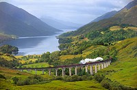 The Jacobite Steam Train, better known now as the Harry Potter Train, crossing the viaduct of Glenfinnan with loch Shiel in the background. Scotland. ...