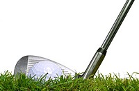 Shot of a golf ball lying on the fairway with an iron club behind, surface level studio shot using real grass