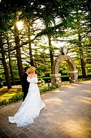 Bride and groom walking hand in hand in a park