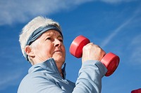 Britain, UK, Europe  Senior woman exercising with dumbbell hand weights outdoors  MR 10/02