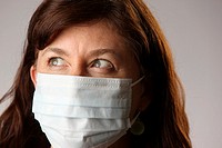 Woman wearing surgical mask to protect herself from contracting contagious influenza viruses like H1N1 Swine Flu