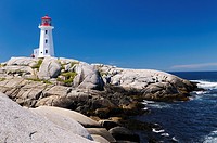 Peggys Cove Nova Scotia lighthouse on smooth granite rocks with accordian player and surf