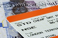 Close-up of UK cheap day return train ticket and banknotes