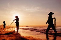 Three women in traditional hats on Mui Ne Beach, Vietnam  Fishing at sunrise