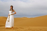 Girl dressed like Cleopatra posing on the desert dunes