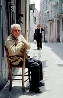 Old elderly local people men in street of hill town of Randazzo, central Sicily, Italy