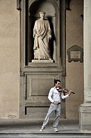 Florence, Italy  Street musician plays classical violin under statue of city father Cosimo de Medici  Outside the Uffizi Gallery