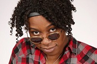 Young African-American woman looking over sunglasses posing for portrait