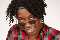 Young African-American woman looking over sunglasses posing for portrait