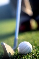 Close-up of Golfer addressing golf ball with golf club about to hit
