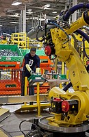 Detroit, Michigan - A worker and a robot on the assembly line for Chrysler´s new Jeep Grand Cherokee at the Jefferson North Assembly Plant