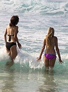 Two Women In The Ocean - Two young women just entering the ocean on the Big Island of Hawaii, USA