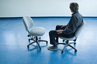 Man sitting on a chair in an empty office